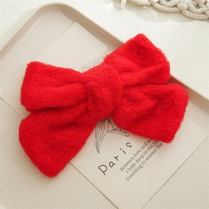 Détail macro d'un nœud papillon en peluche rouge avec texture douce sur un plateau