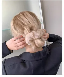 Gros plan d'un chouchou duveteux en fausse fourrure kaki pour une coiffure élégante