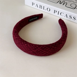 Detail of burgundy thick tweed headband with hand made label and woven texture
