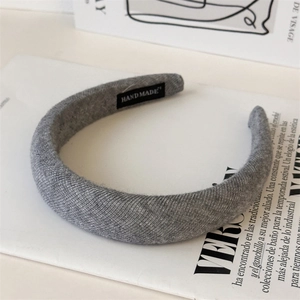 Detail showing grey knitted headband texture with a handmade woven label accent