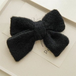 Gros plan d'un grand nœud à cheveux en peluche noire avec une texture douce et un design élégant