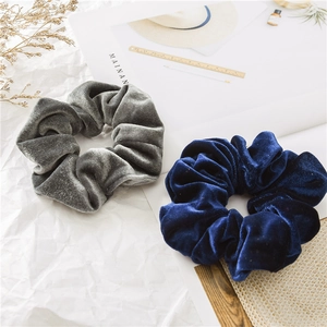 Dettaglio di elastici scrunchie in velluto grigio scuro e blu reale dalla trama morbida