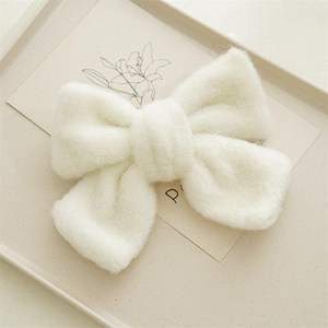 Détail de la texture douce et du tissu pelucheux blanc du nœud papillon pour les cheveux