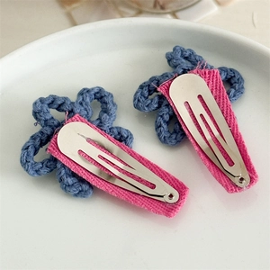 Close-up of blue crochet flower hair clips with pink fabric wrapped metal BB clips
