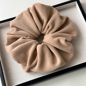 Close-up of a large coffee-colored plush fleece scrunchie with soft velvet texture