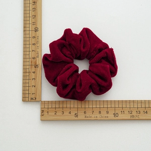 Detail view of large burgundy velvet hair scrunchie with 9cm diameter measurement