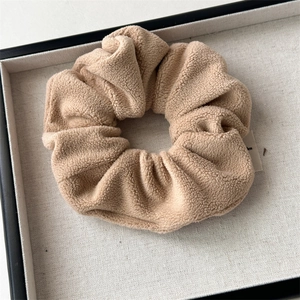 Close-up of soft plush coffee-colored hair scrunchie with textured fleece in a tray