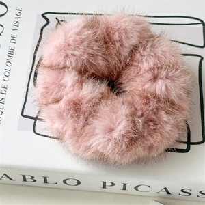Gros plan détaillé d'un chouchou en peluche rose sur un fond de livre blanc minimaliste