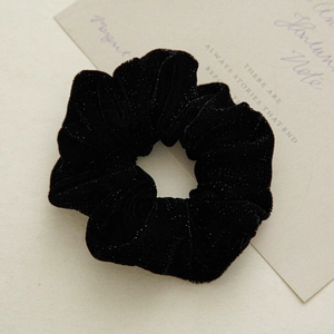 Detail of premium black velvet scrunchie with silver glitter and soft texture