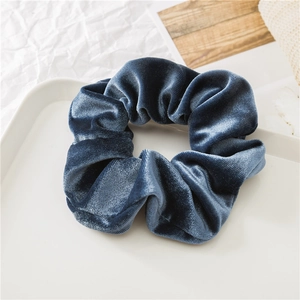 Vista dettagliata di un elastico per capelli in velluto blu scuro dalla trama morbida