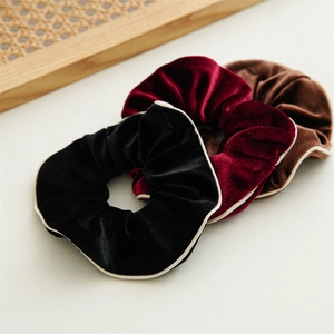 Three-piece set of elegant velvet hair scrunchies in black, burgundy, and brown with white trim
