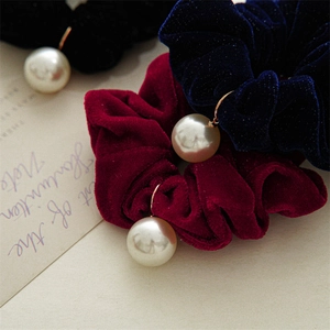 Close-up of velvet scrunchies in black, navy and burgundy with pearl pendant detail
