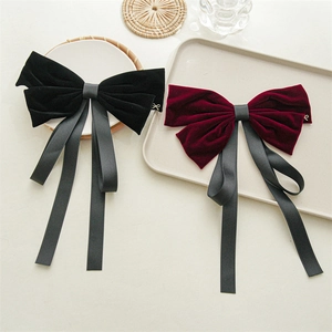 Detail of vintage black and burgundy velvet bow hair clips with long satin ribbons