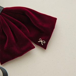 Detailed close-up of premium deep red velvet bow hairpin with gold metal butterfly charm