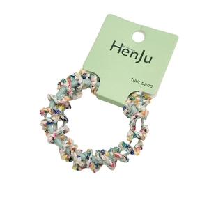 Élastique à cheveux tissé en spirale vert avec fils colorés sur carte de présentation