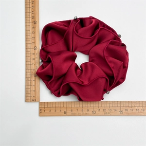 Burgundy satin scrunchie with white pearl accents and elegant glossy finish