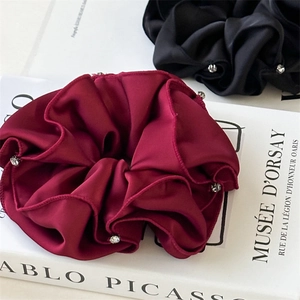 Detailed view of burgundy and black satin scrunchies with sparkling rhinestone accents
