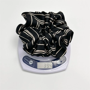 Elegant satin striped scrunchie in black and white displayed on a scale showing 39.4g weight