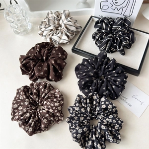 Flat lay of six floral and striped satin scrunchies in a stylish home decor setting