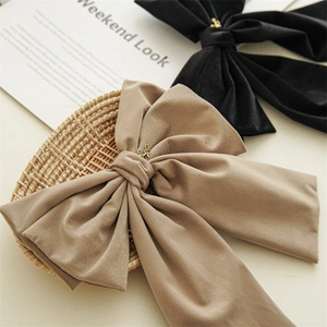 Detail of velvet bow hair clips with long ribbons and elegant golden metal charms