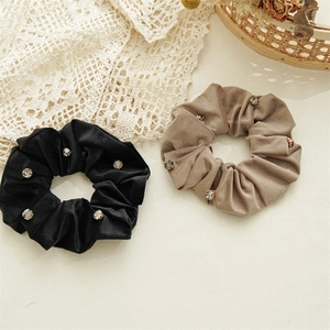 Detailed view of luxury velvet scrunchies with rhinestones in black and khaki colors
