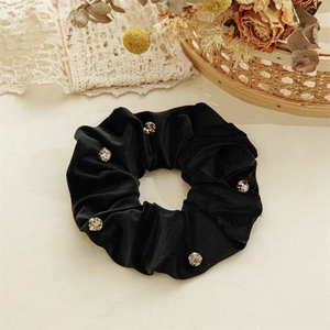 Detailed view of luxury black velvet hair scrunchie with sparkling silver rhinestones