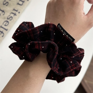 French vintage red plaid scrunchie with silver beads worn on wrist for hair styling