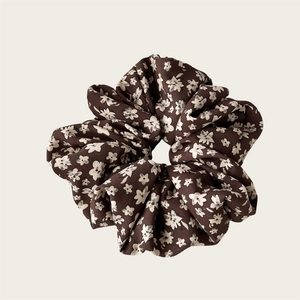 Elegant wide floral fabric hair scrunchie with white flower pattern on dark brown textile