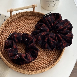 Close-up of red plaid scrunchies with rhinestone accents in a woven basket