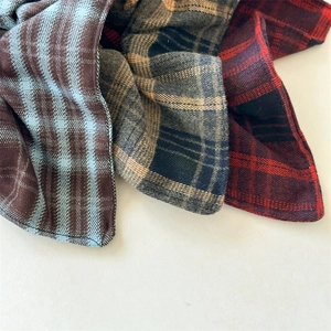 Close-up of red and blue plaid fabric texture with precise stitching for hair accessories
