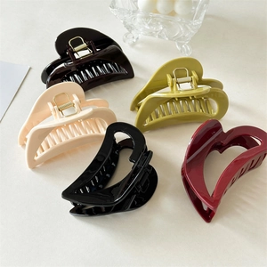 Detail view of five heart-shaped hair claws in brown, olive, cream, black, and burgundy