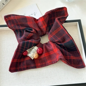 Detail of red and black plaid scrunchie featuring vintage SMILE label and decorative beads