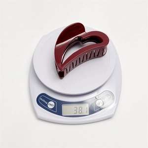 French vintage heart hair claw in wine red finish showing 38.1g weight on a scale