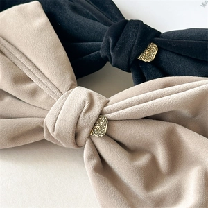 Detailed macro view of plush velvet bow hair clips with elegant vintage gold metal buckles