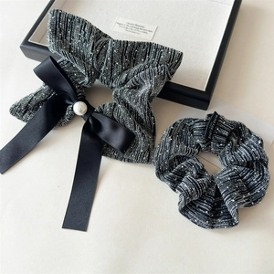 Detail of luxury black tweed bow scrunchie set with white pearl and satin ribbon decor