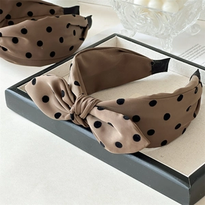 Detailed close-up of brown polka dot headbands with elegant bow and knot designs