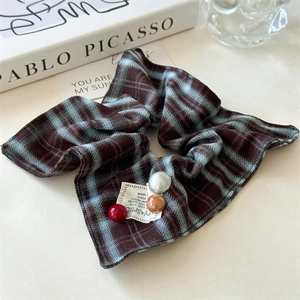 Detailed shot of vintage plaid scrunchie with colorful button charms and texture