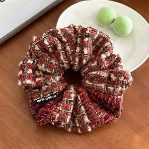 Détail du chouchou en tweed à carreaux avec texture tissée et étiquette de marque