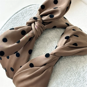 Close-up of the brown polka dot satin bow headband with soft velvet dot textures