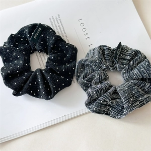 Close-up of fabric scrunchies with polka dots, metallic glitter and woven logo tags