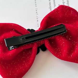 Detailed back view of red velvet bow hair clip with silver glitter and metal duckbill clip