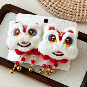 Détail de pinces à cheveux danse du lion en peluche avec pompons rouges et broderies