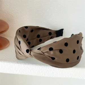 Detailed view of brown knotted polka dot headband with soft velvet texture and comfy tips