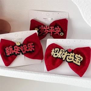 Detail of red velvet bow hair clips with festive Chinese greetings on white packaging