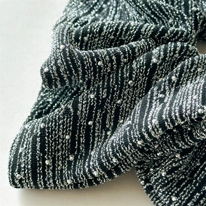 Macro shot of striped knit hair scrunchie with silver rhinestones and metallic texture