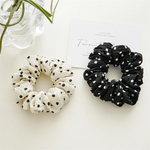 Close-up of elegant black and white polka dot scrunchies in a stylish two-piece set