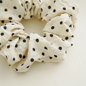 Macro shot of polka dot scrunchie fabric with wrinkled texture and elastic core