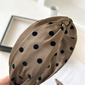 Detail of retro brown satin wide knotted headband with black flocked polka dots