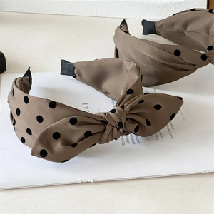 Brown satin headband with black polka dots and large bow in a stylish design