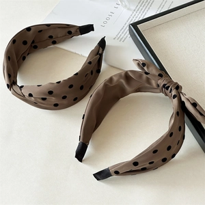 Macro detail of coffee brown polka dot fabric headbands with satin finish and knots